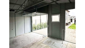 6x5m-es prémium mobilgarázs nyeregtetővel, +20cm emeléssel, sötét diófa falakkal, antracitszürke kapuval, ajtóval és tetővel, 2db ablakkal. ereszcsatornával, szegélyekkel