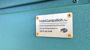 3,5x7m-es sztenderd mobilgarázs nyeregtetővel (1m-es előtetővel), zöld színben, kétszárnyú kapuval, ablakokkal, ereszcsatornával, szegélyezéssel