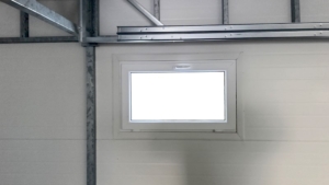 6x5,8m-es DELUX szigetelt mobilgarázs, nyeregtetővel, sötét diófa falakkal, antracitszürke szekcionált kapuval és ajtóval, szegélyekkel, ereszcsatonával, horganyzott vázszerkezettel