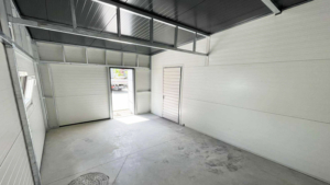 10x6m-es DELUX szigetelt mobilgarázs fordított nyeregtetővel, 2db szekcionált kapuval, 2db ajtóval, ablakkal, 3db szellőzőráccsal, ereszcsatornával, cserepeslemez tetőborítással, horganyzott vázszerkezettel