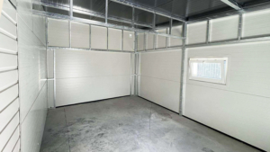 10x6m-es DELUX szigetelt mobilgarázs fordított nyeregtetővel, 2db szekcionált kapuval, 2db ajtóval, ablakkal, 3db szellőzőráccsal, ereszcsatornával, cserepeslemez tetőborítással, horganyzott vázszerkezettel