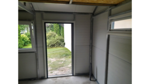 4,5x7m-es DELUX szigetelt mobilgarázs / tároló jobbra lejtő tetővel, szekcionált kapuval, ajtóval, ablakkal, szegélyekkel, ereszcsatornával, horganyzott vázszerkezettel